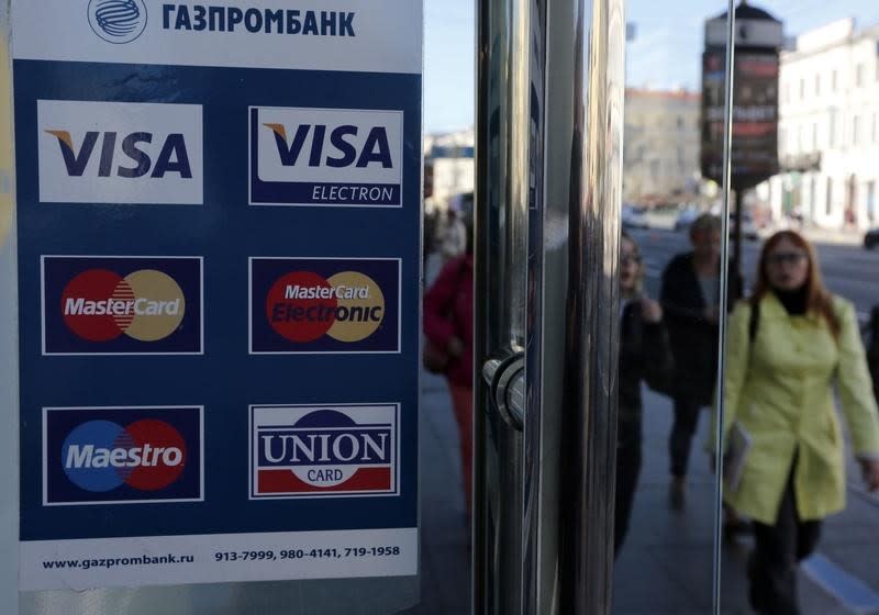 A sign with a logo of Gazprombank for Visa, MasterCard and Union Card is seen on the door of a shop in St. Petersburg, September 16, 2014. REUTERS/Alexander Demianchuk