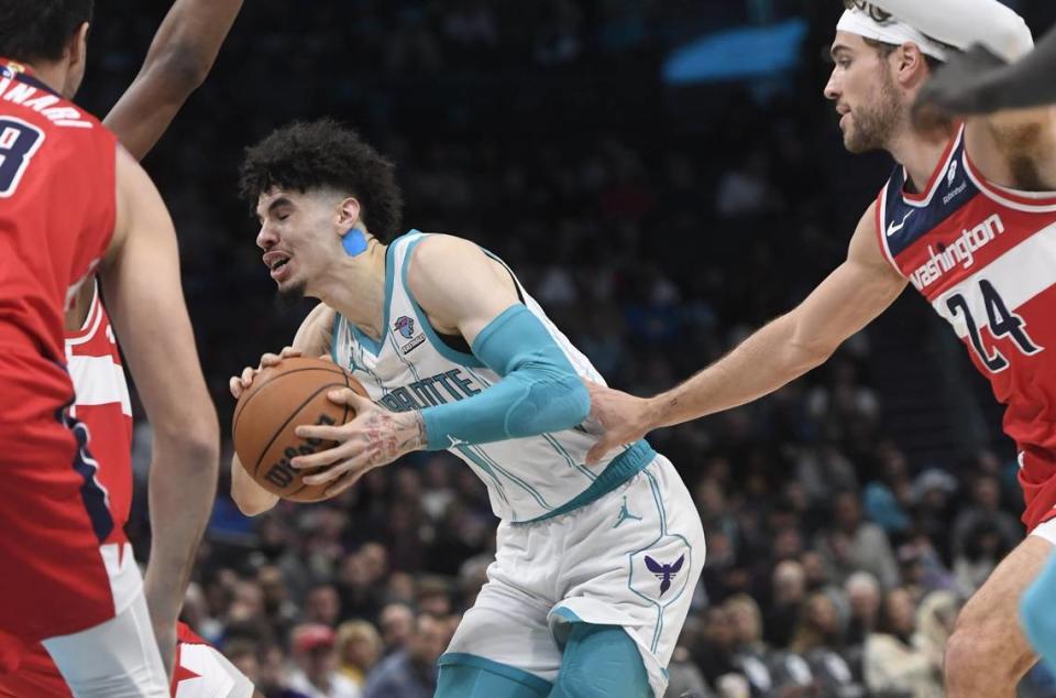 Hornets guard LaMelo Ball drives past Wizards forward Corey Kispert during Friday’s game. The NBA is making Ball cover up his “LF” tattoo, citing a policy against exposing commercial logos on players’ bodies. LF stands for Ball’s middle name, LaFrance, which also is now a clothing line. / Sam Sharpe-USA Today Sports