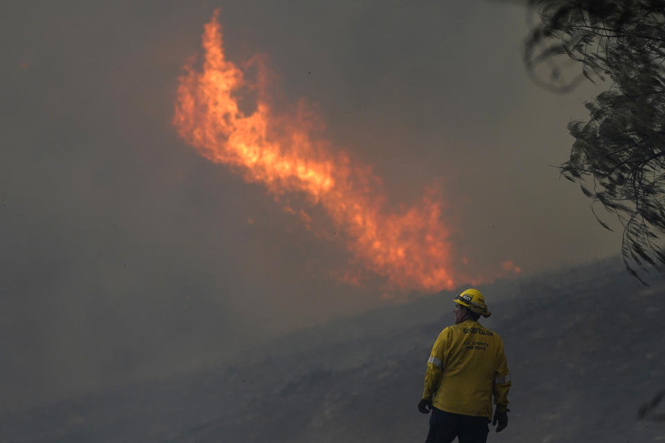 Firefighter Brad Goodfellow, of the Los Angeles County Engine 80, watches the Route Fire as it burns a ridge Wednesday, Aug. 31, 2022, in Castaic, Calif. (AP Photo/Marcio Jose Sanchez)