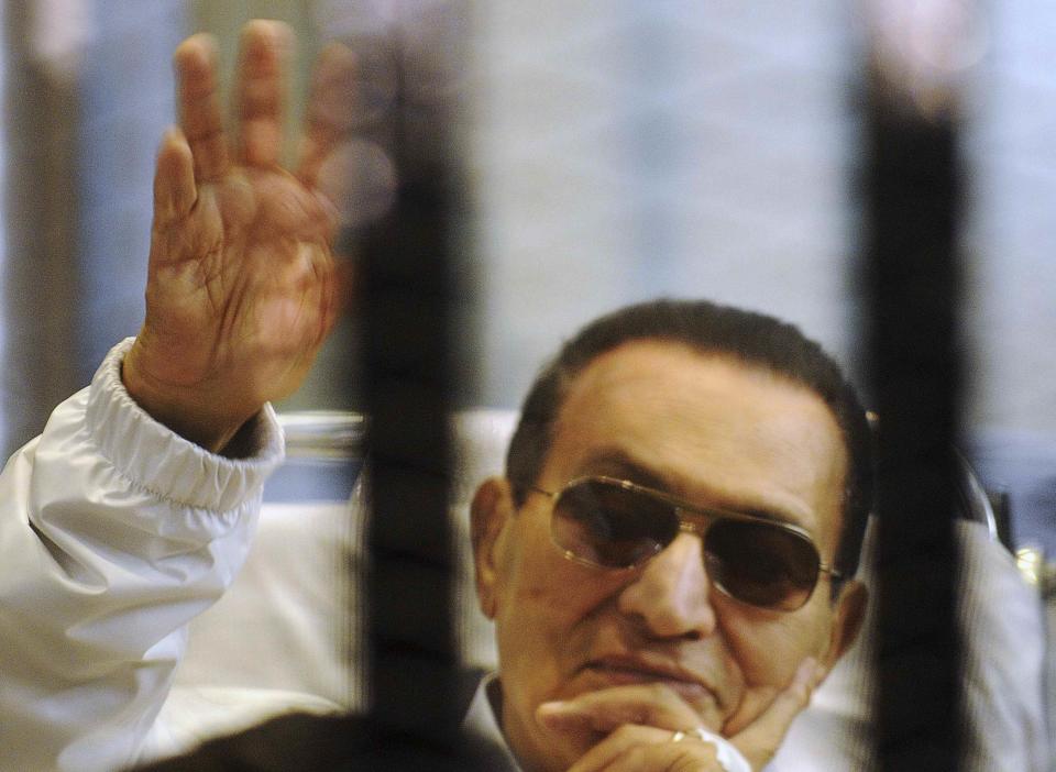 RNPS - PICTURES OF THE YEAR 2013 - Former Egyptian President Hosni Mubarak waves to his supporters inside a cage in a courtroom at the police academy in Cairo April 13, 2013. The retrial of former Egyptian President Mubarak was aborted then when the presiding judge withdrew from the case and referred it to another court, causing an indefinite delay that sparked anger in the courtroom. REUTERS/Stringer (EGYPT - Tags: POLITICS CRIME LAW TPX)