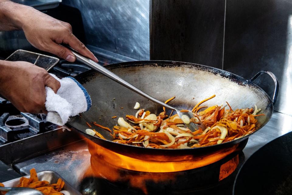 Chef/owner Lord Maynard Llera prepares vegetables for his pancit chami.