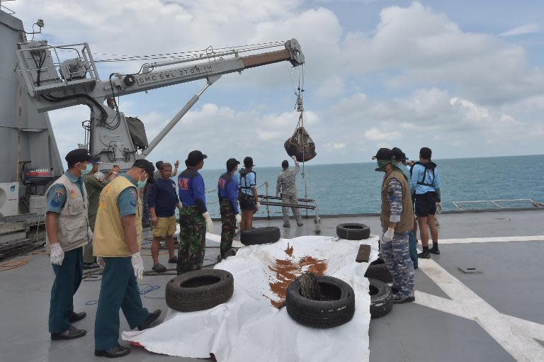 Indonesia Navy personnel recover two dead bodies onboard the navy vessel KRI Banda Aceh during operations to lift the tail of AirAsia flight QZ8501 in the Java Sea on January 9, 2015