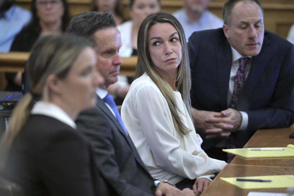 Karen Read, center, listens as the prosecutor questions Dr. Marie Russell, during Read's trial in Norfolk Superior Court, Friday, June 21, 2024, in Dedham, Mass. Read, 44, is accused of running into her Boston police officer boyfriend with her SUV in the middle of a nor'easter and leaving him for dead after a night of heavy drinking. (AP Photo/Josh Reynolds, Pool)