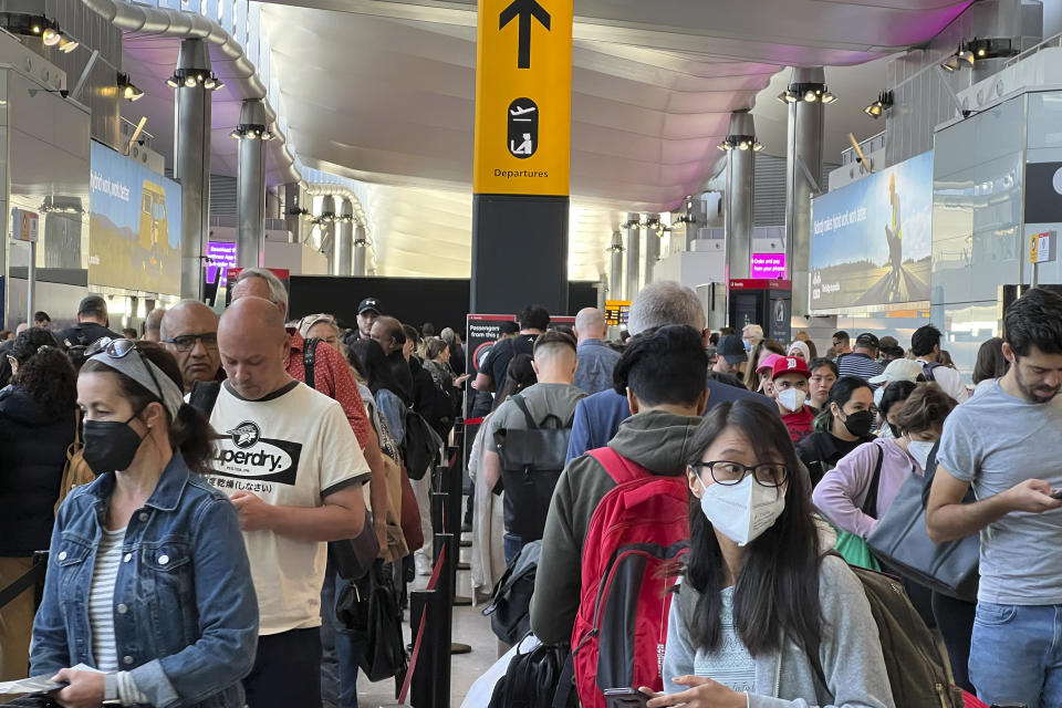 FILE - Travellers queue at security at Heathrow Airport in London, Wednesday, June 22, 2022. London’s Heathrow Airport apologized Monday, July 11, 2022 to passengers whose travels have been disrupted by staff shortages. The airport warned that it may ask airlines to cut more flights from their summer schedules to reduce the strain if the chaos persists. (AP Photo/Frank Augstein, File)