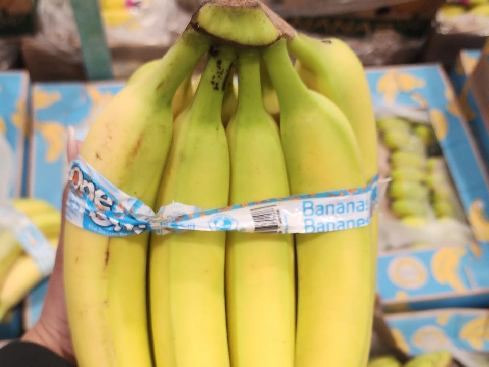 The writer holds a bunch of bananas