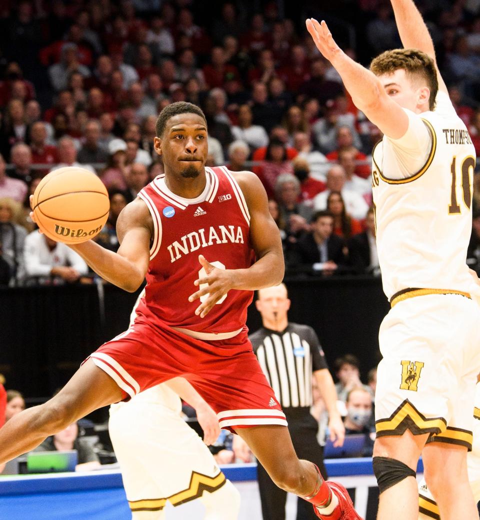 Indiana's Xavier Johnson (0) passes around Wyoming's Hunter Thompson (10) during the First Four game.