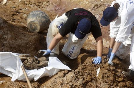 Forensic experts, members of the International Commision of Missing Persons (ICMP) and Bosnian workers search for human remains at a mass grave in the village of Tomasica near Prijedor, October 22, 2013. REUTERS/Dado Ruvic