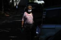 Lina Barrios walks outside the ICU of the Respiratory Hospital INERAM where her son is being treated for COVID-19 in Asuncion, Paraguay, Wednesday, March 3, 2021. Barrios said she has had to buy her son's medication at pharmacies because the hospital is out, costing her $8,400 in two weeks. (AP Photo/Jorge Saenz)