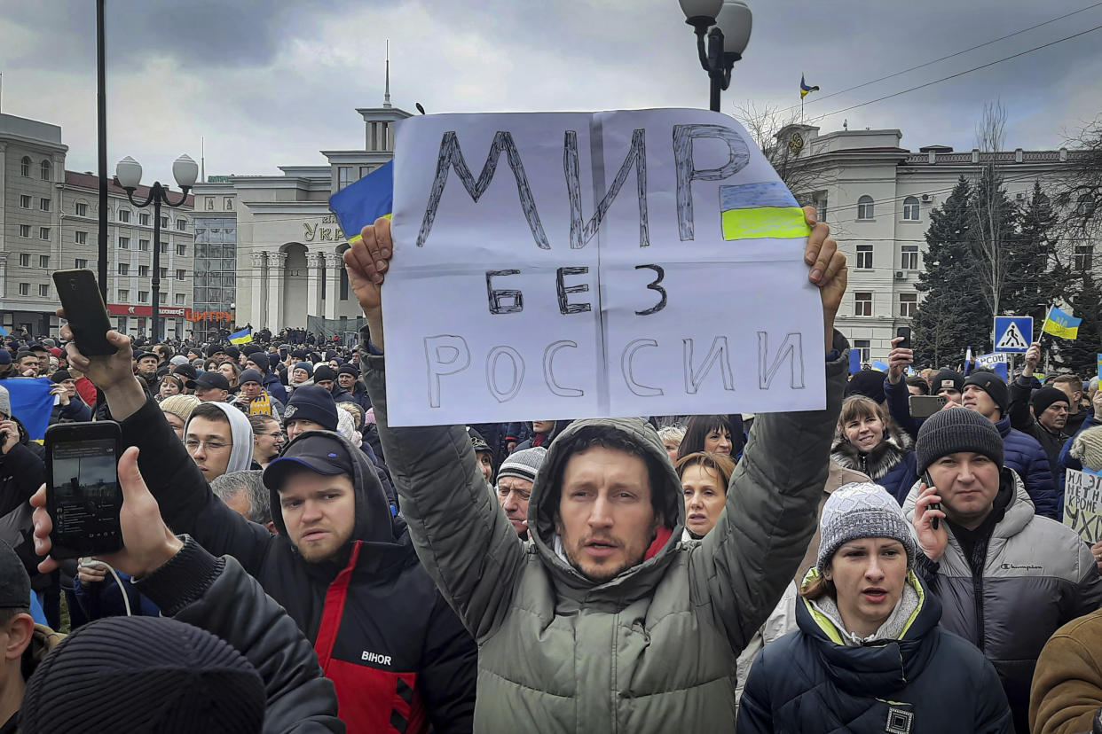 FILE - A man holds a banner that reads: "World without Russia", during a rally against the Russian occupation in Svobody (Freedom) Square in Kherson, Ukraine, on March 5, 2022. According to Russian state TV, the future of the Ukrainian regions occupied by Moscow's forces is all but decided: Referendums on becoming part of Russia will soon take place there, and the joyful residents who were abandoned by Kyiv will be able to prosper in peace. In reality, the Kremlin appears to be in no rush to seal the deal on Ukraine's southern regions of Kherson and Zaporizhzhia and the eastern provinces of Donetsk and Luhansk. (AP Photo/Olexandr Chornyi)