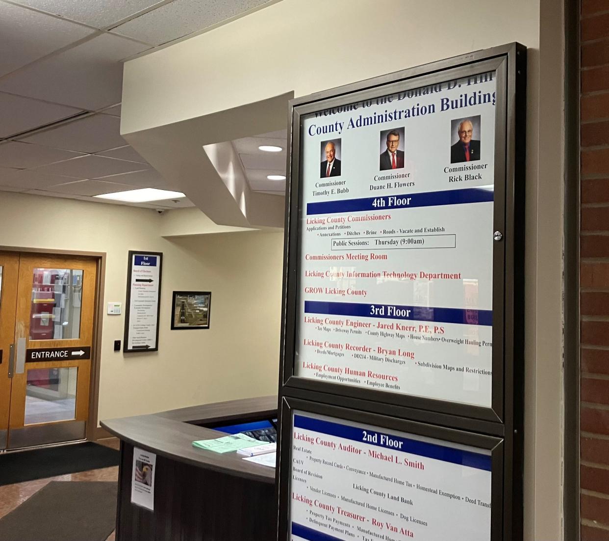 A building directory includes photos of Licking County commissioners Friday at the county administration building.