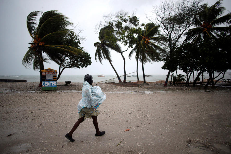 A woman protects herself from rain as Hurricane Matthew approaches in Les Cayes