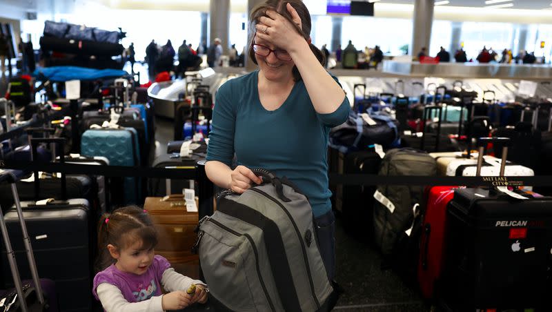 Casandra Friend, of Provo, laughs as her daughter asks for a toy after collecting their luggage at the Southwest luggage carousel at the Salt Lake City International Airport in Salt Lake City on Friday, Dec. 30, 2022. 