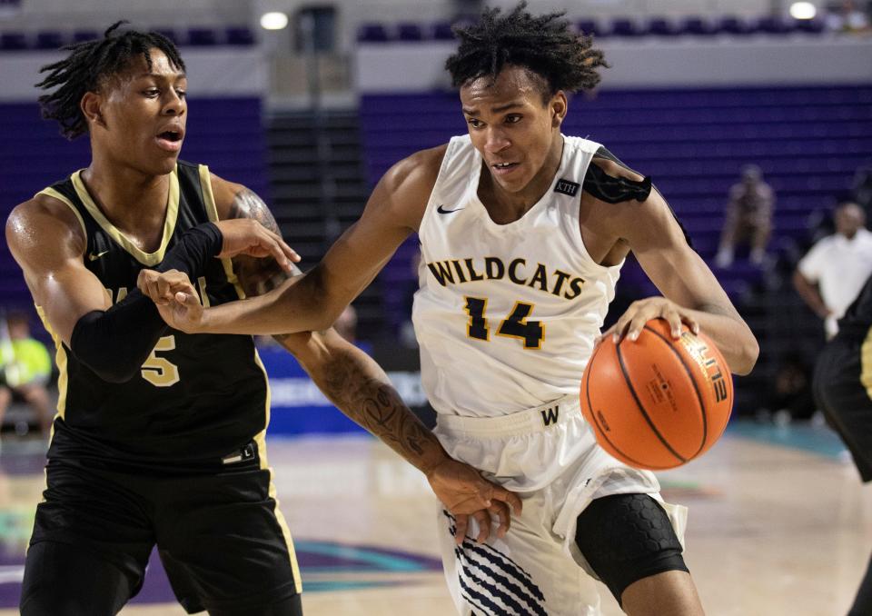 Josh Hill of Wheeler drives around DeShawn Harris-Smith of Paul VI in the City of Palms Classic Third-Place Championship game on Wednesday, Dec. 21, 2022, at Suncoast Credit Union Arena in Fort Myers.