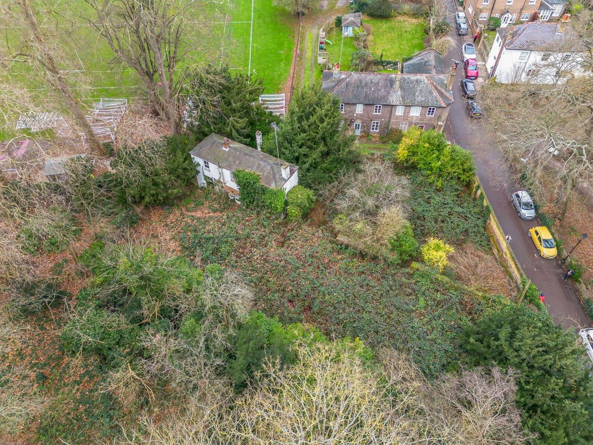 The house is obscured by the brick wall that encloses the site (Savills)