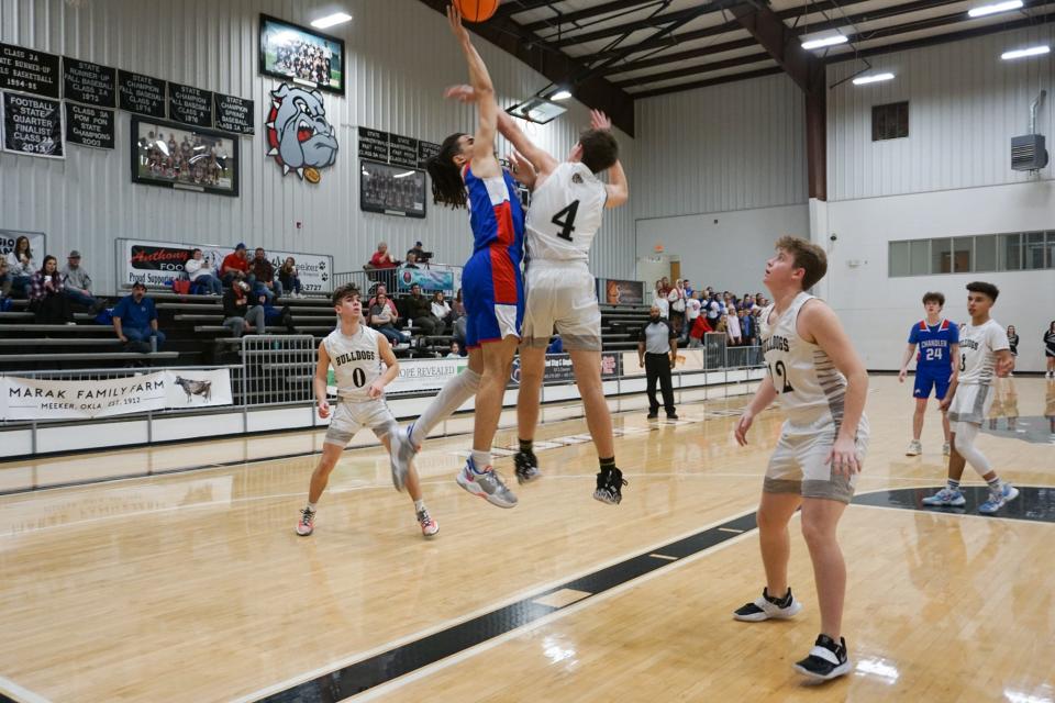 Chandler senior Isaiah Holland goes up for the shot over Meeker junior Devin Sligar Tuesday night.