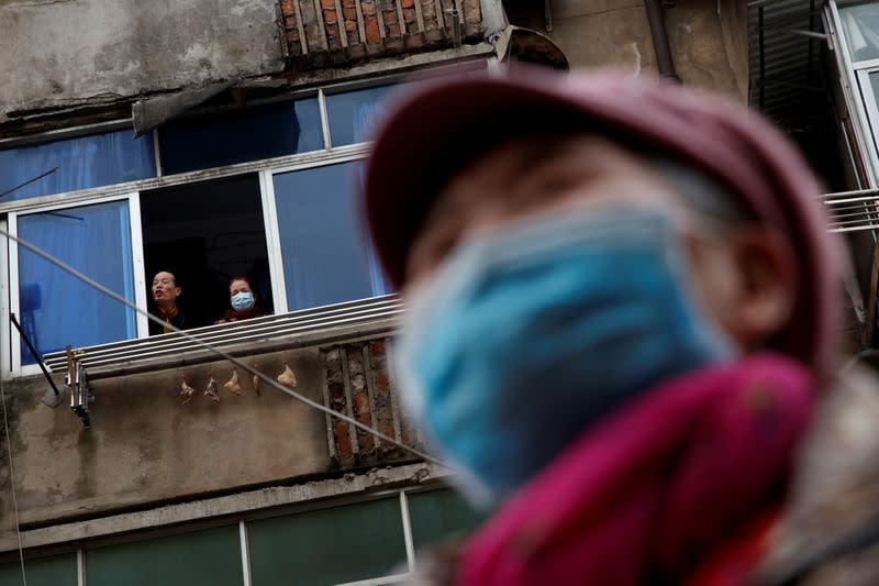 FILE PHOTO: People wear protective masks in an old neighbourhood of Jiujiang