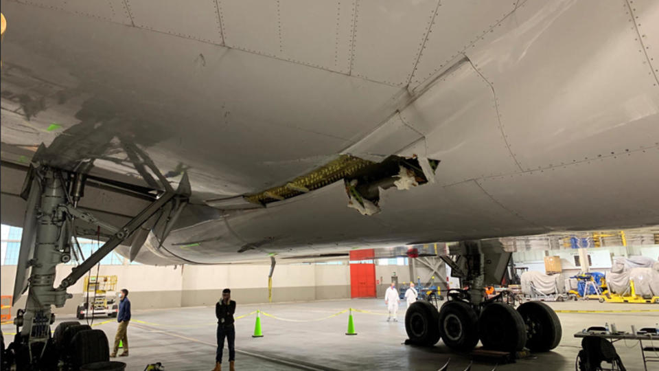 Image taken February 22, 2021, shows the damage to the wing and the body fairing of the United Airlines flight 328 Boeing 777-200 following an engine failure incident Saturday.  / Credit: NTSB