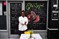 Etta Burrell, owner of Etta's Seafood Kitchen, stands outside her restaurant at Brixton Village in London