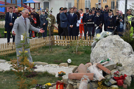 Britain's Prince Charles gestures in front of a memorial for the victims of the earthquake during his visit to the town of Amatrice, which was levelled after an earthquake last year, in central Italy April 2, 2017. REUTERS/Emiliano Grillotti