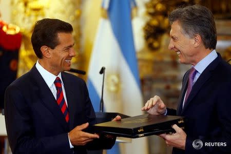 El presidente de Argentina, Mauricio Macri (derecha), y su contraparte de México, Enrique Peña Nieto, intercambian regalos en la casa de gobierno Casa Rosada en Buenos Aires, Argentina, 29 de julio de 2016. Los mandatarios firmaron el viernes acuerdos de complementación económica con los que apuntan a avanzar hacia el libre comercio bilateral el próximo año. REUTERS/Enrique Marcarian