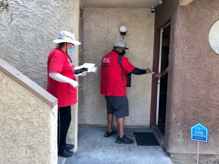 Maria Magana,left, and Atilano Salgado go door to door canvassing in Las Vegas.