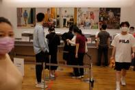 Customers line up at a payment counter inside a store of the Fast Retailing's fashion chain Uniqlo, in Beijing