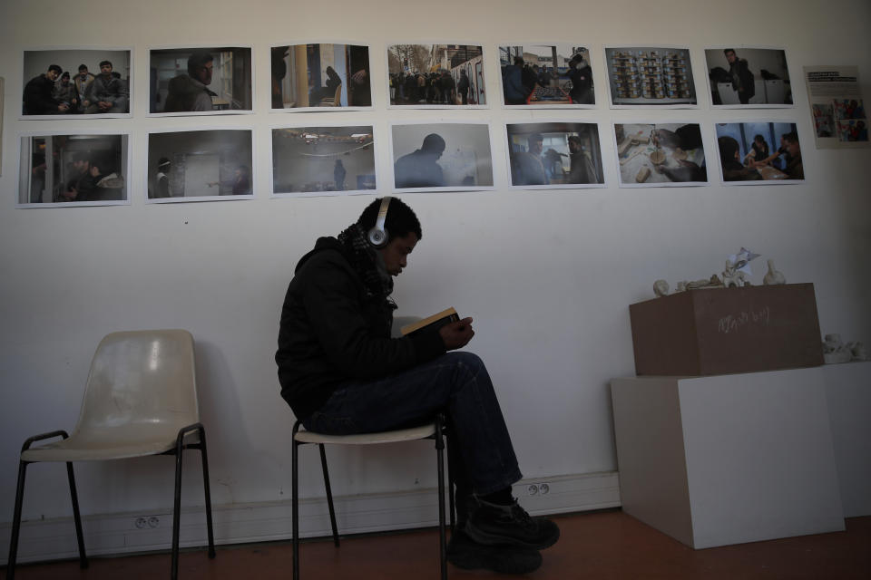 A man reads a book in the "Aurore" center for homeless and migrants in Paris, Thursday, April 2, 2020. Amid the coronavirus lockdown, charity workers at France's Aurore association, are preparing more than a thousand meals a day for migrants and the homeless on the half-abandoned grounds of a former Paris hospital whose patron saint was devoted to the poor. (AP Photo/Francois Mori)