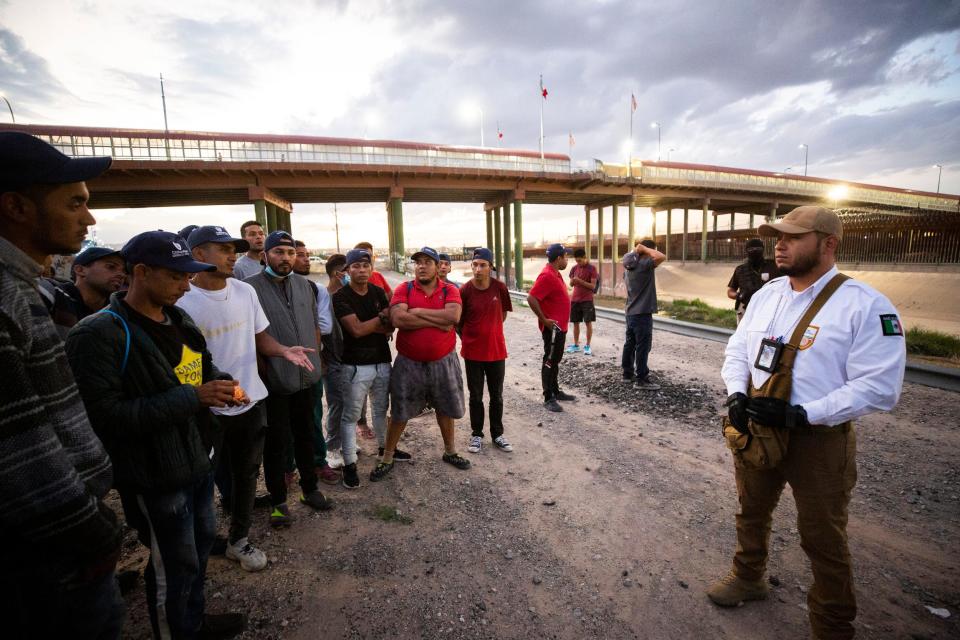 Venezuelan migrants speak to a Mexican immigration officer about their situation on the south bank of the Rio Grande after the migrants were expelled from the U.S. to Ciudad Juárez on Oct, 15, 2022.