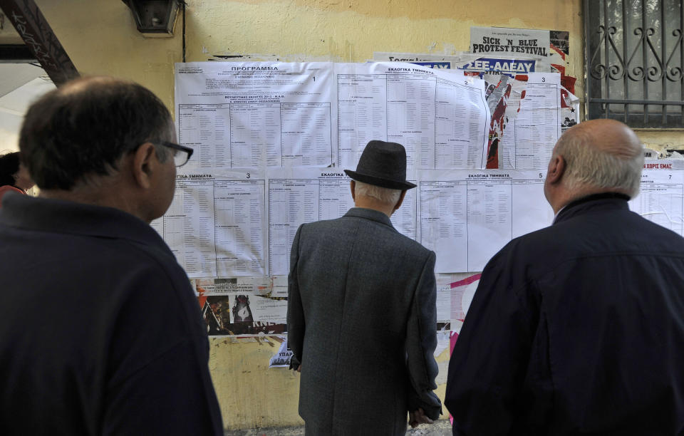 People check voting lists outside a polling station in Thessaloniki, northern Greece Sunday May 6, 2012. Greeks cast ballots on Sunday in their most critical _ and uncertain _ election in decades, with voters set to punish the two main parties that are being held responsible for the country's dire economic straits. (AP Photo/Nikolas Giakoumidis)