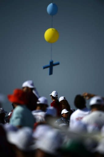 A cross hangs from balloons as youth wait for the arrival of Pope Benedict XVI in the Lebanese mountain village of Bkerke