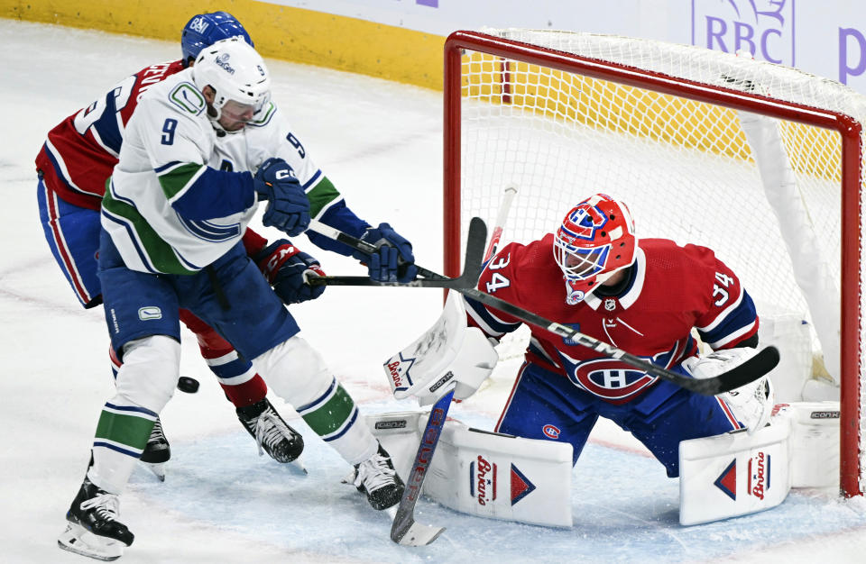 Vancouver Canucks' J.T. Miller (9) moves in against Montreal Canadiens goaltender Jake Allen, right, during first-period NHL hockey game action in Montreal, Sunday, Nov. 12, 2023. (Graham Hughes/The Canadian Press via AP)