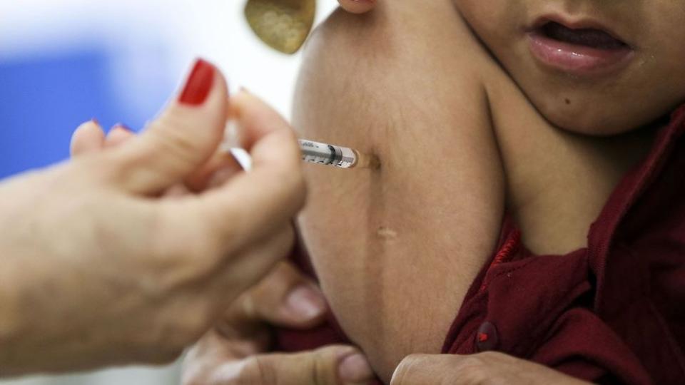 Menino recebendo vacina por meio de injeção intramuscular