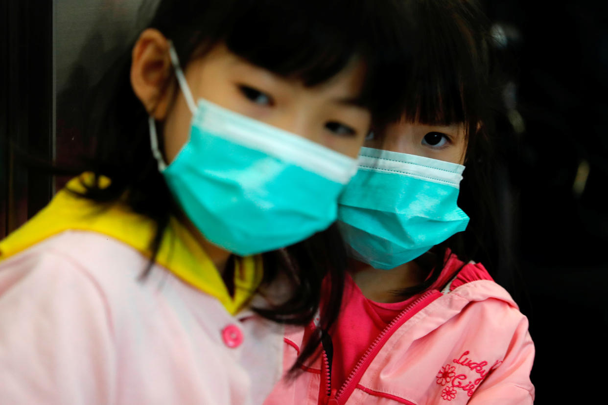 Children wear masks to prevent an outbreak of a new coronavirus at the Hong Kong West Kowloon High Speed Train Station, in Hong Kong, China January 23, 2020. REUTERS/Tyrone Siu