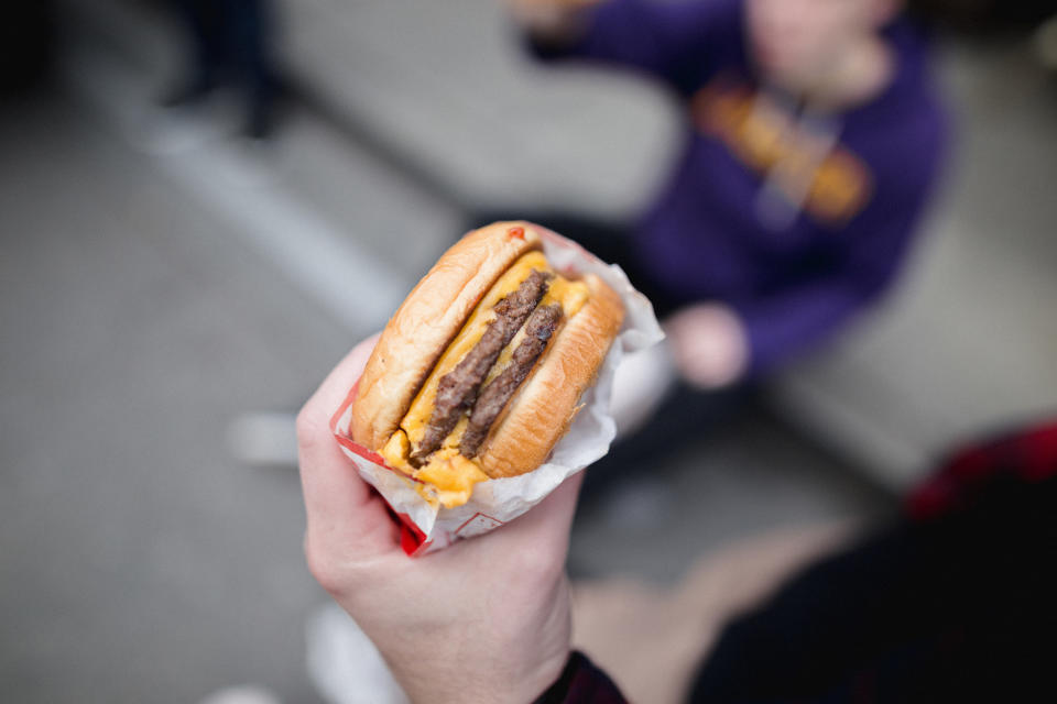 A person holding a double-meat, double-cheese burger.