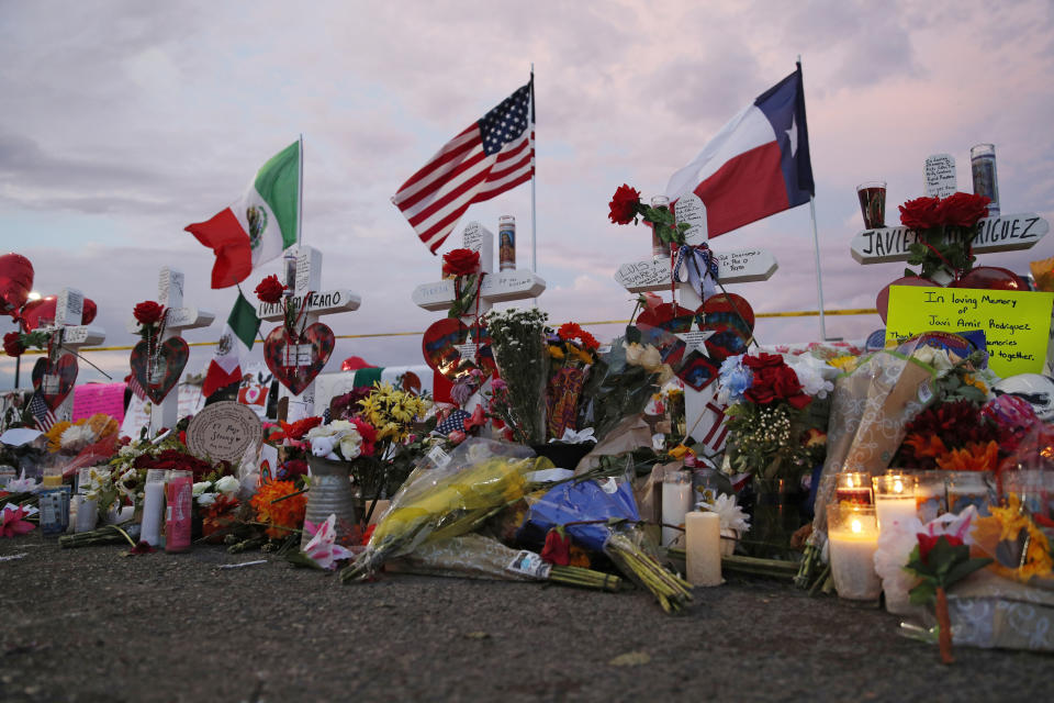 Flags fly over crosses at a makeshift memorial near the scene of a mass shooting at a shopping complex Tuesday, Aug. 6, 2019, in El Paso, Texas. The border city jolted by a weekend massacre at a Walmart absorbed more grief Monday as the death toll climbed and prepared for a visit from President Donald Trump over anger from El Paso residents and local Democratic leaders who say he isn't welcome and should stay away. (AP Photo/John Locher)