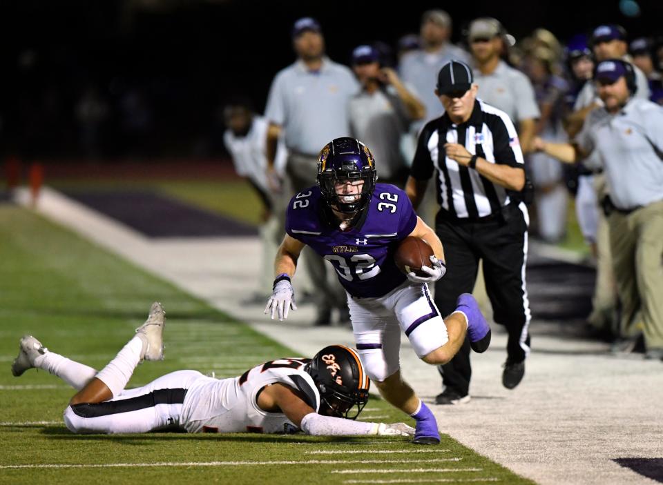 Wylie running back Landry Carlton slips past El Paso linebacker Edgar Garcia before stepping out of bounds during a Class 5A first-round playoff game Nov. 10 in Abilene.