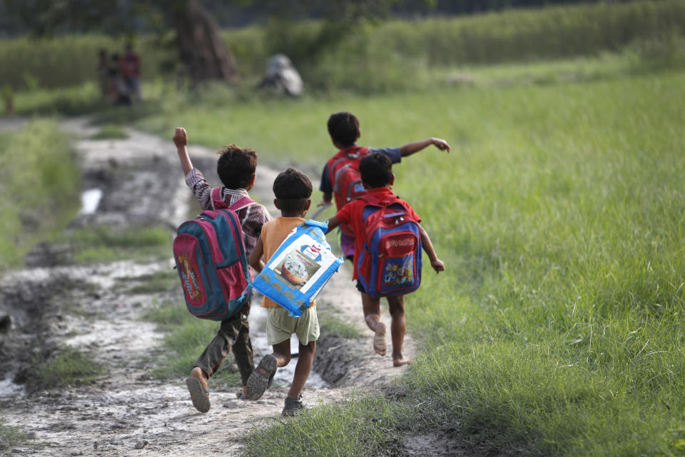 Children return home after their class on a sidewalk in New Delhi, India, on Sept. 3, 2020. An Indian couple, Veena Gupta and her husband Virendra Gupta, is conducting free classes for underprivileged children on a sidewalk in New Delhi with the goal to keep them learning and not left behind when schools reopen. It all began when Veena's maid complained that with schools shut, children in her impoverished community were running amok and wasting time. As most schools in India remain shut since late March when the country imposed a nationwide lockdown to curb the spread of COVID-19, many switched to digital learning and taking classes online. (AP Photo/Manish Swarup)