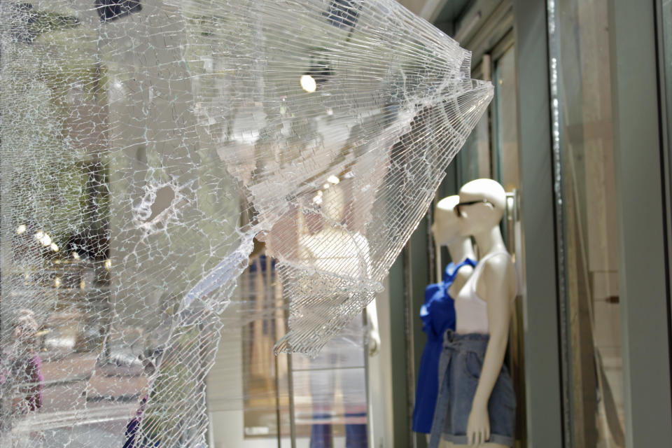 Mannequins are seen through shattered glass at an H&M store in downtown Portland, Ore., Monday, July 13, 2020, after protests the night before. While most demonstrations in the city have been peaceful, nightly violent clashes between police and protesters have divided Portland, paralyzed the downtown and attracted the attention of President Donald Trump, who sent federal law enforcement to the city to quell the unrest. (AP Photo/Gillian Flaccus)