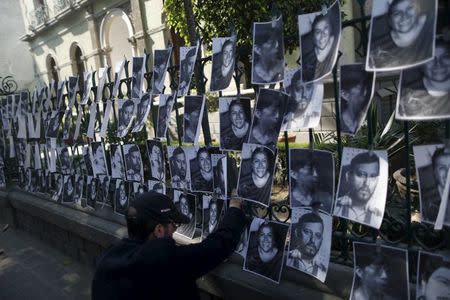 A man hangs images of murdered journalists during a demonstration against the murder of a journalist Anabel Flores outside the Government of Veracruz building in Mexico City, February 11, 2016. REUTERS/Edgard Garrido