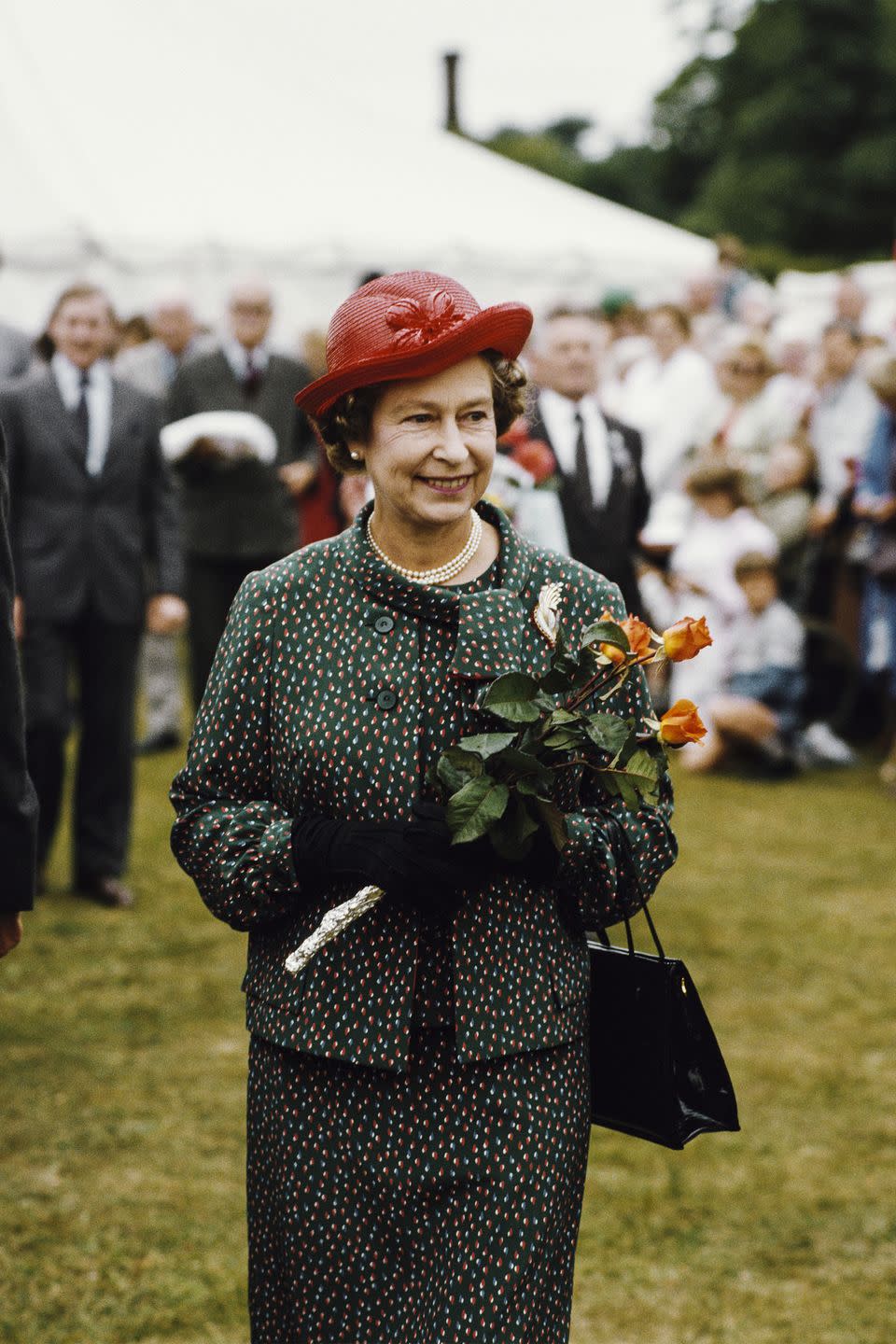 <p>The queen looked marvelous in a green printed suit with flares of orange and white during the Sandringham Flower Show in Sandringham, Norfolk.<br></p>