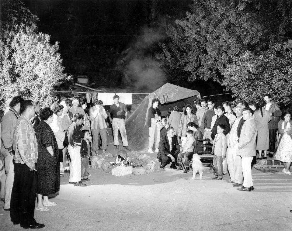 L.A. Councilman Edward Roybal, center, speaks with members of Aréchiga family, who were camping near their home after they were evicted.