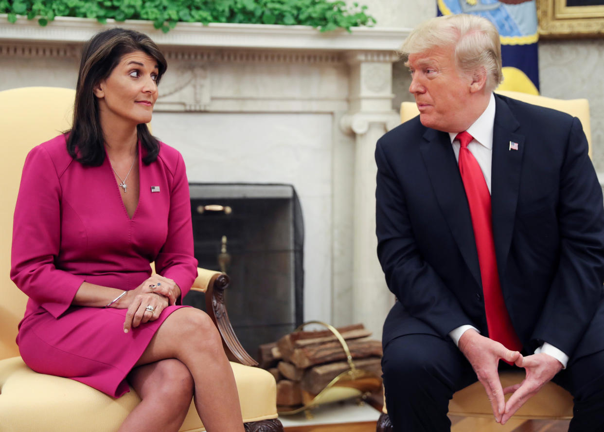 Nikki Haley looks quizzical as President Donald Trump leans in toward her.