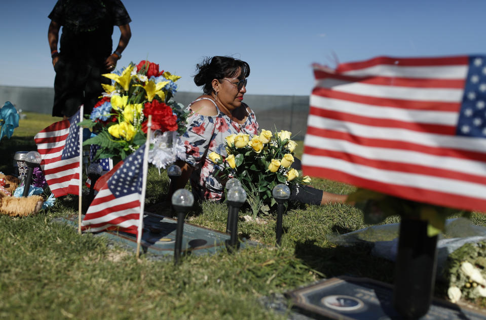 Angelica Cervantes sits at her son Erick Silva's grave Saturday, Sept. 29, 2018, in Las Vegas. Silva was one of 58 people killed Oct. 1, 2017, in the deadliest mass shooting in modern U.S. history. Silva was working as a security guard at the Route 91 Harvest Festival and was shot while helping people climb over a barricade to escape the gunfire. (AP Photo/John Locher)