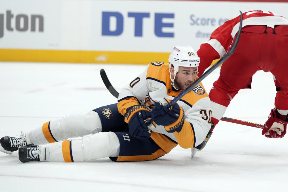 Nashville Predators center Ryan O'Reilly (90) falls after shooting the puck during the first period of an NHL hockey game against the Detroit Red Wings, Friday, Dec. 29, 2023, in Detroit. (AP Photo/Carlos Osorio)