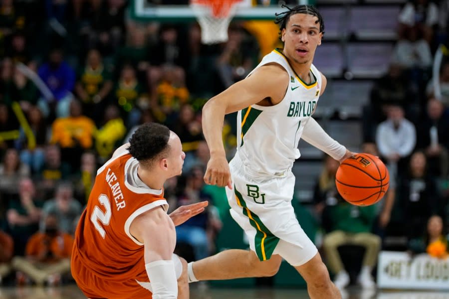 Baylor’s Miro Little, right, dribbles past Texas’s Chendall Weaver (2) during the first half of an NCAA college basketball game, Monday, March 4, 2024, in Waco, Texas. (AP Photo/Julio Cortez)