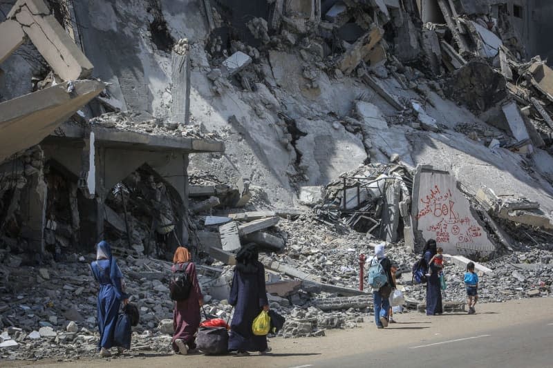 Palestinians carry their belongings as they flee Hamad City towards Al-Mawasi after the Israeli army dropped leaflets demanding that residents of a northern neighborhood in Khan Younis evacuate immediately ahead of a new military operation in the Gaza Strip. Abed Rahim Khatib/dpa