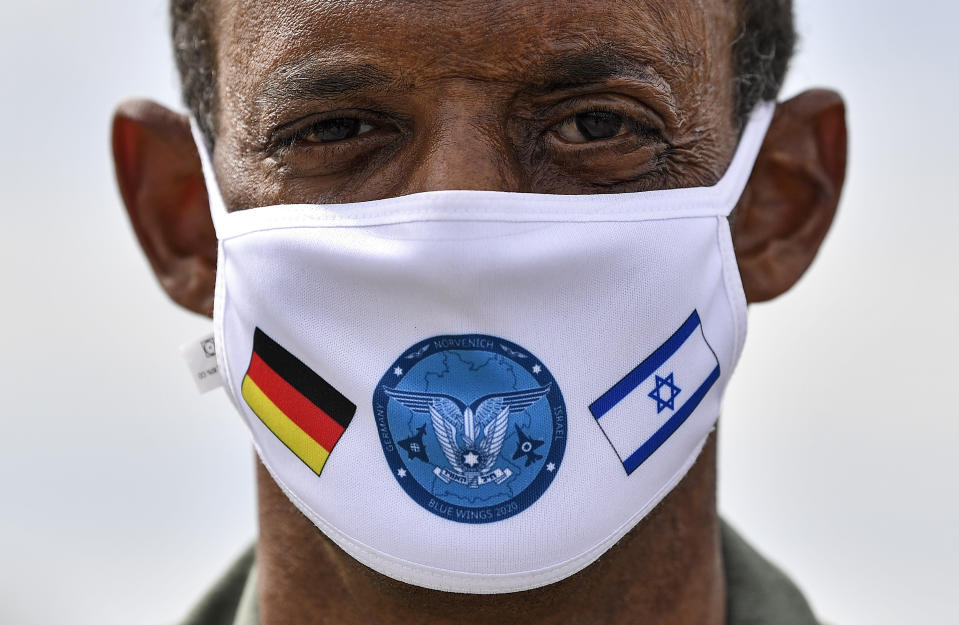 German Lieutenant colonel Samuel Mbassa wears a face mask with the flags of Israel and Germany at the airbase in Noervenich, Germany, Thursday, Aug. 20, 2020. Pilots from Israel and Germany will fly together the next two weeks during the first joint military Air Force exercises between the two nations in Germany. (AP Photo/Martin Meissner)