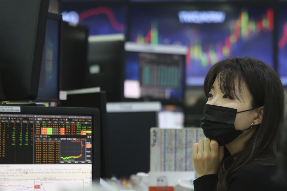 A currency trader wearing a face mask watches monitors at the foreign exchange dealing room of the KEB Hana Bank headquarters in Seoul, South Korea, Friday, Feb. 21, 2020. Asian stock markets have followed Wall Street lower after a rise in virus cases in South Korea refueled investor anxiety about China's disease outbreak. (AP Photo/Ahn Young-joon)