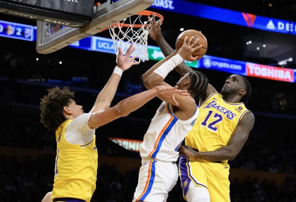 Lakers forward Taurean Prince and center Jaxson Hayes try to block a shot by Oklahoma City Thunder guard Aaron Wiggins.