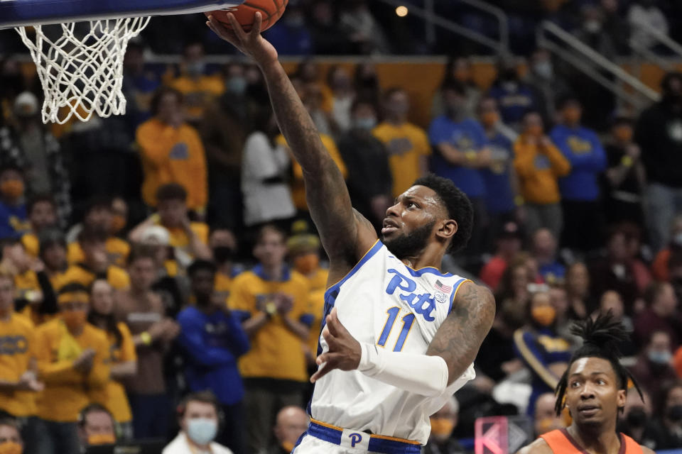 Pittsburgh's Jamarius Burton (11) scores past Virginia Tech's Justyn Mutts during the second half of an NCAA college basketball game, Saturday, Feb. 5, 2022, in Pittsburgh. (AP Photo/Keith Srakocic)